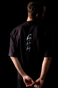 T-shirt 444 noir porté — vue de dos, silhouette minimaliste bras croisés, Marseille.
